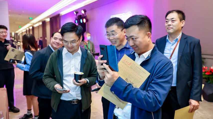 人民網(wǎng)研發(fā)推出的《人民日?qǐng)?bào)》生日?qǐng)?bào)吸引嘉賓體驗(yàn)。主辦方供圖